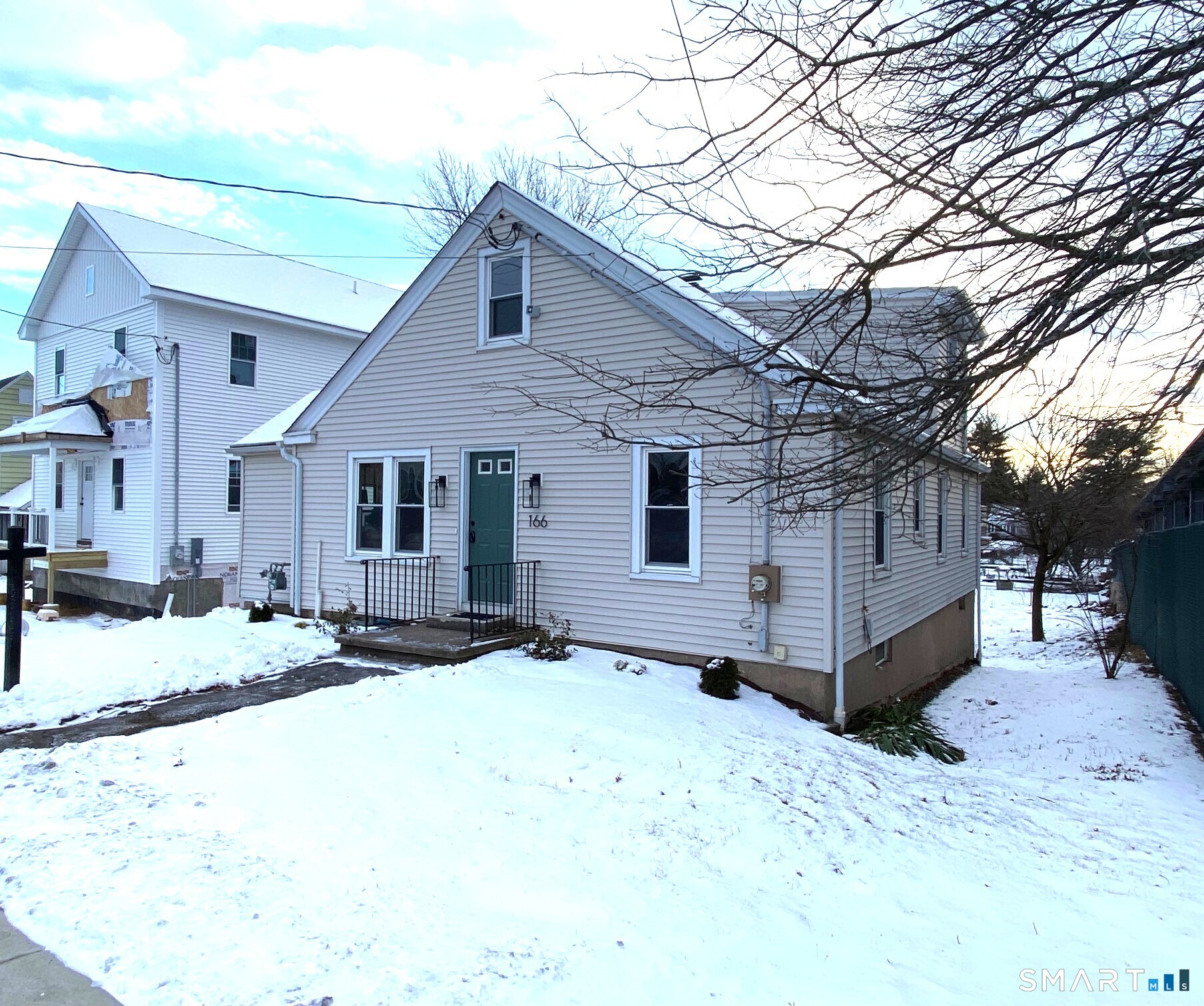 166 Saw Mill Road West Haven, CT 06516 - Photo 3 of 46 a front view of a house with a yard covered in snow