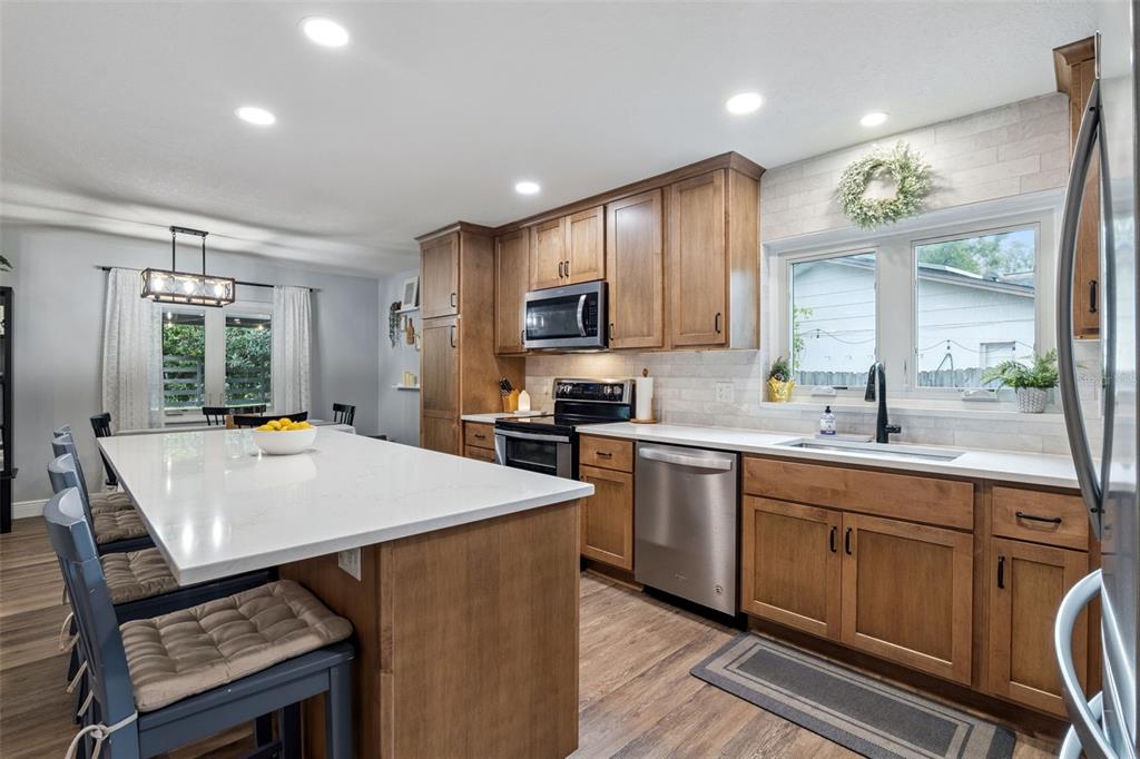 859 Benchwood Drive Winter Springs, FL 32708 - Photo 15 of 35 a kitchen with kitchen island a wooden cabinets a sink a stove and a refrigerator