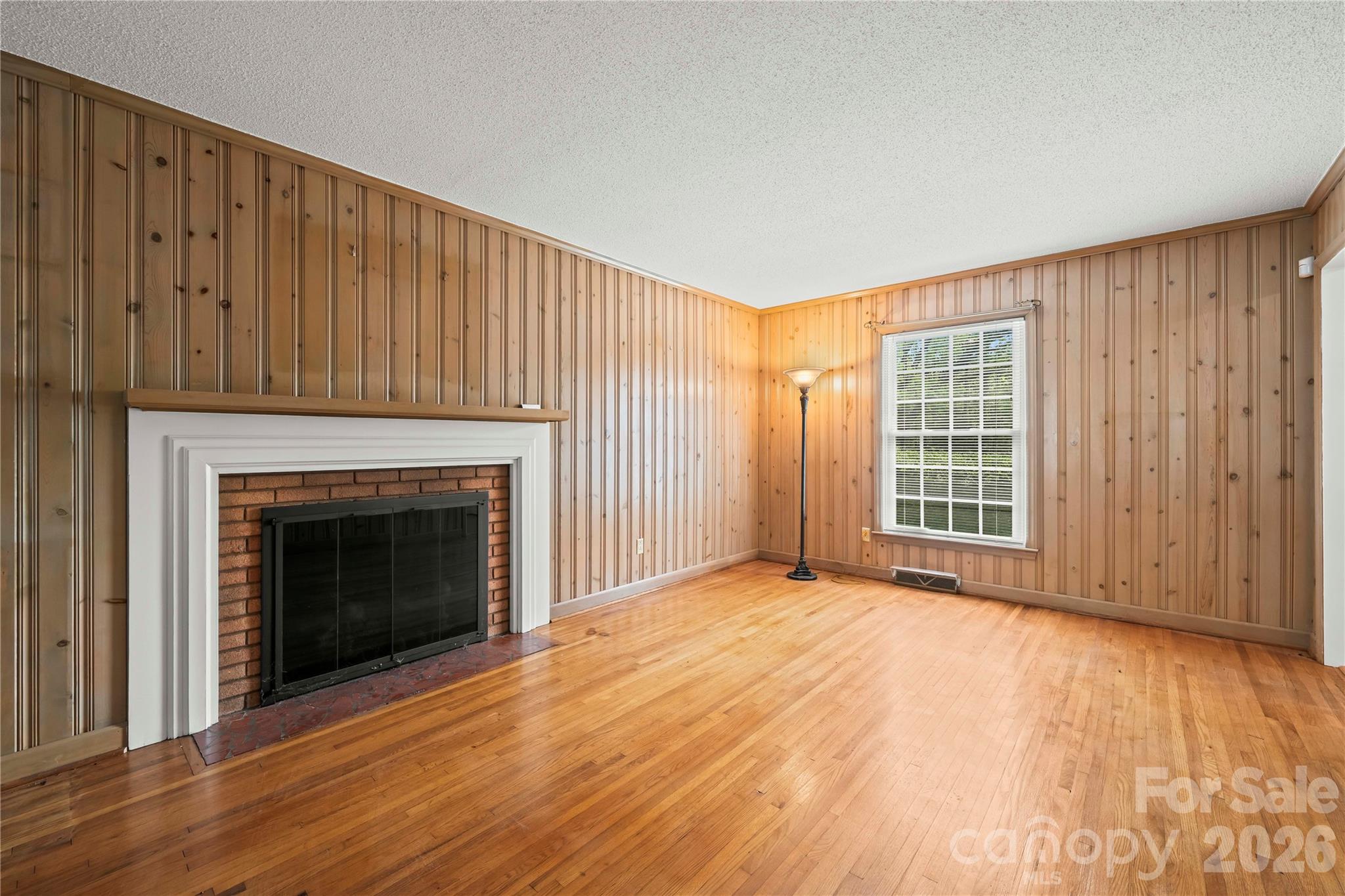 10670 Troutman Road Midland, NC 28107 - Photo 11 of 37 a view of an empty room with wooden floor fireplace and a window