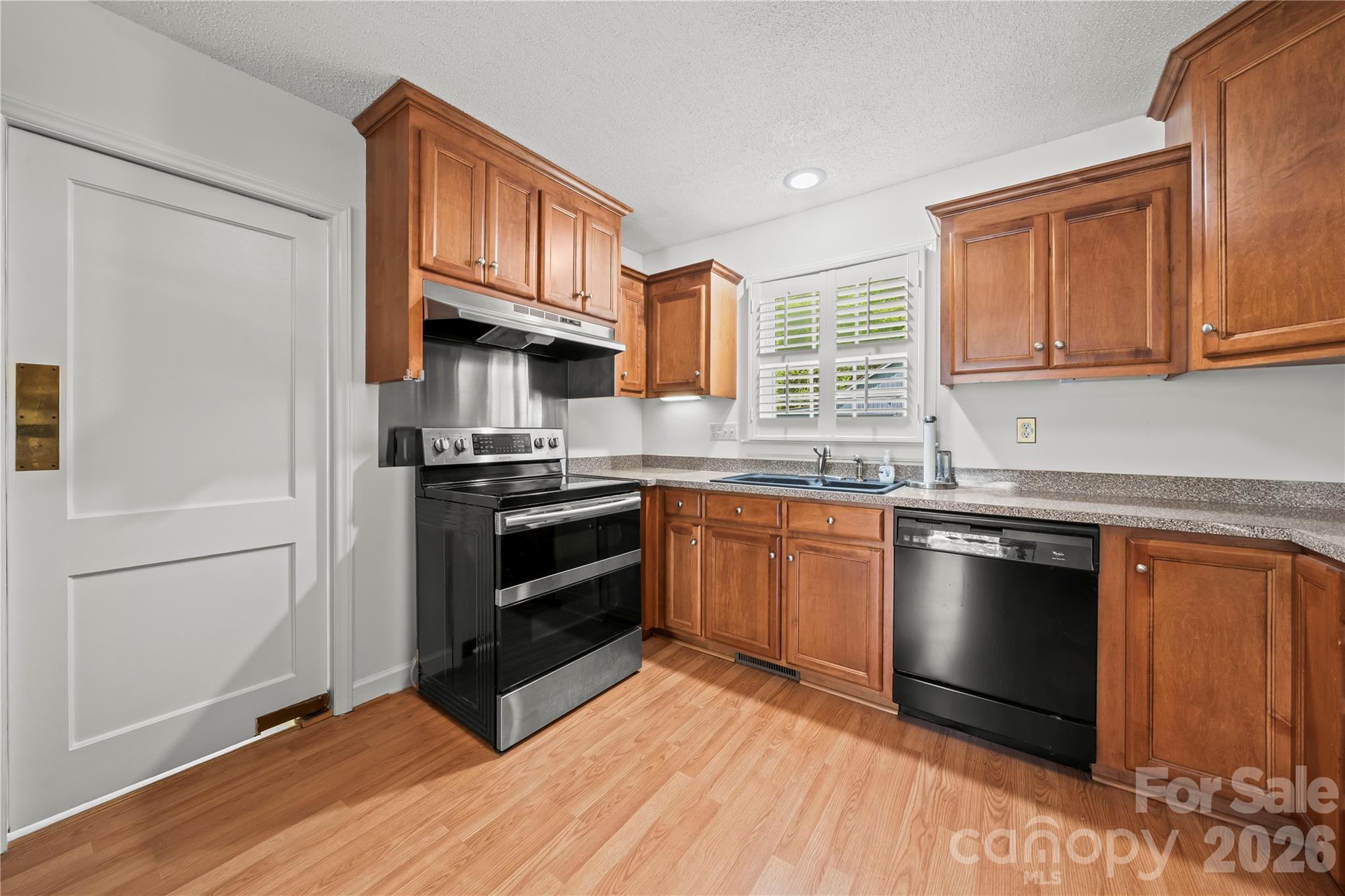 10670 Troutman Road Midland, NC 28107 - Photo 5 of 37 a kitchen with granite countertop stainless steel appliances and wooden cabinets