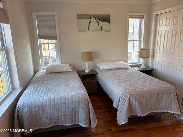 a bedroom with two beds and wooden floor