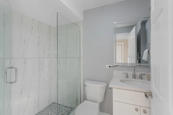 a bathroom with a toilet sink shower and mirror