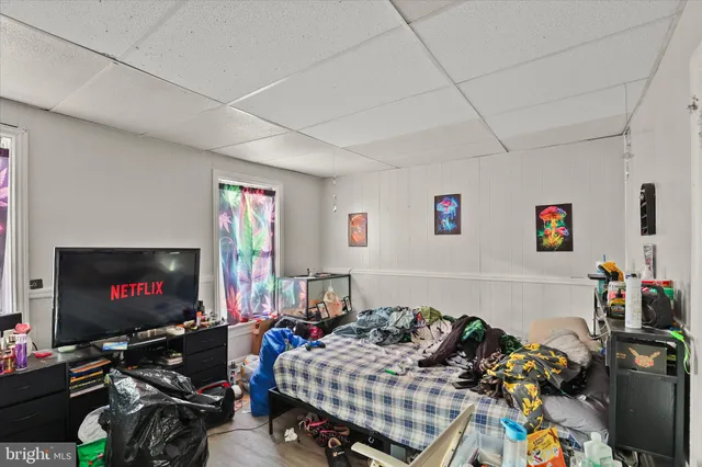 a bedroom with furniture a flat screen tv and a flat screen tv