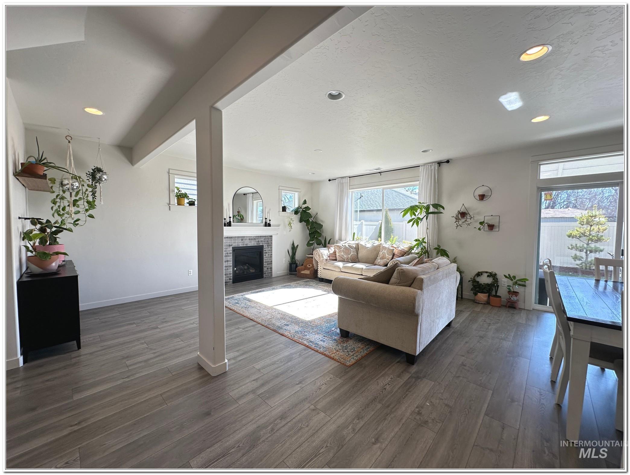 9687 West Arnold Road Boise, ID 83714 - Photo 10 of 49 Living room featuring dark wood finished floors, recessed lighting, healthy amount of natural light, and a brick fireplace