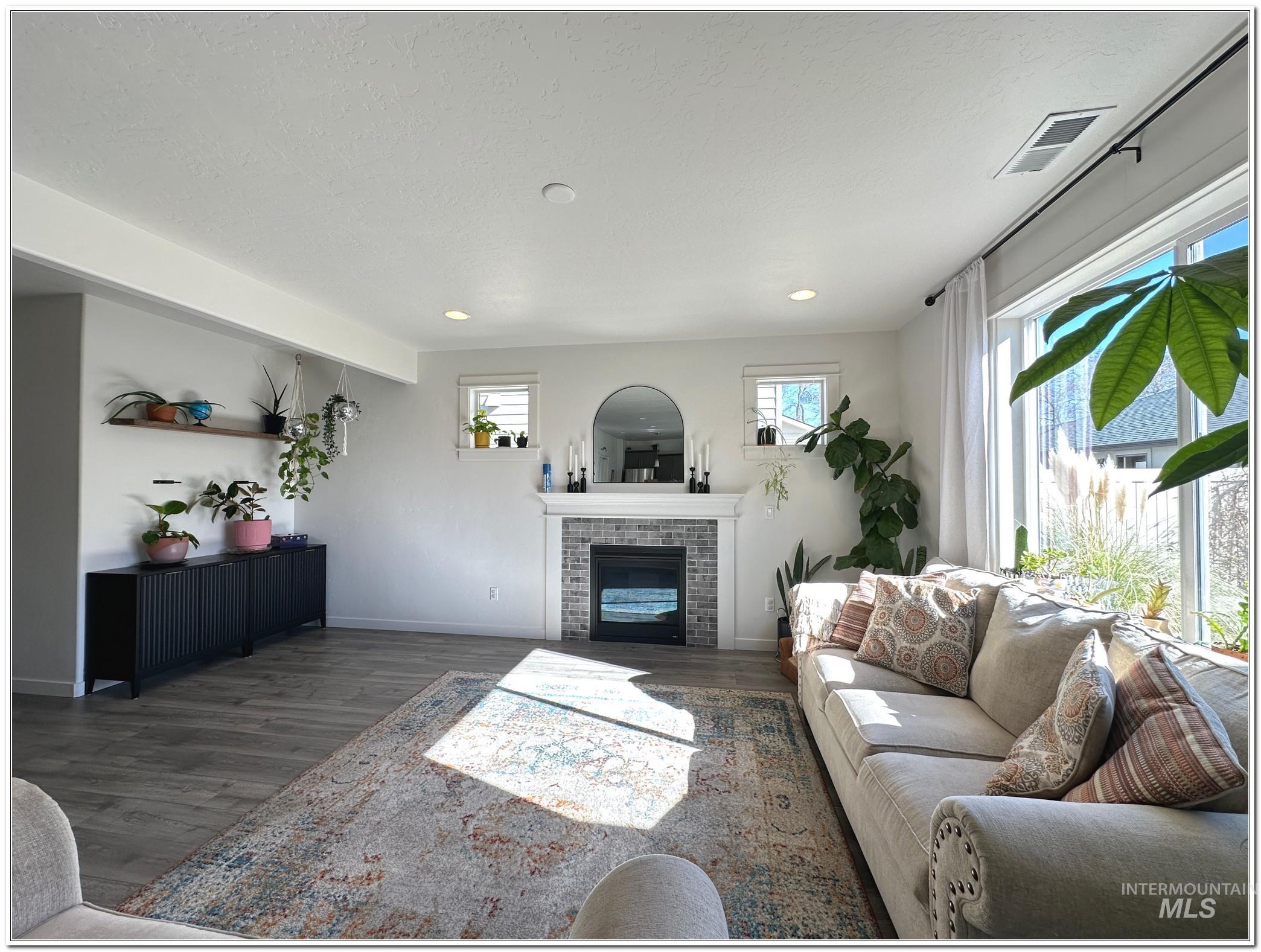9687 West Arnold Road Boise, ID 83714 - Photo 11 of 49 Living room with dark wood-type flooring, a fireplace, and a textured ceiling