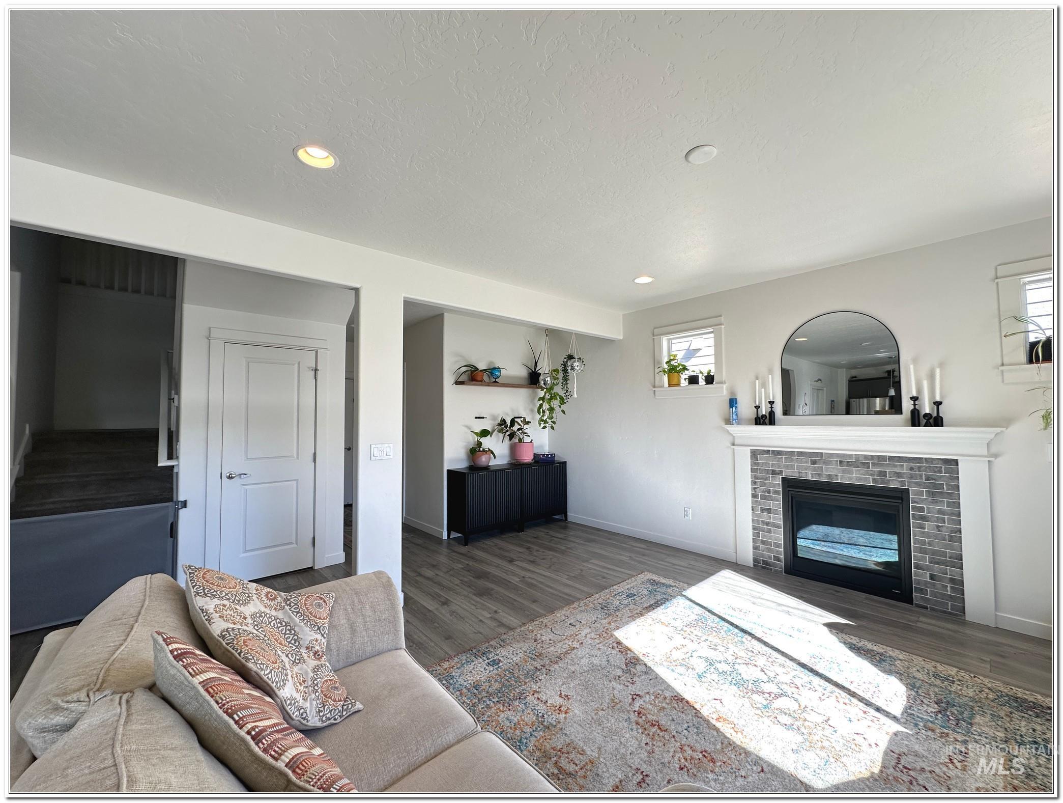 9687 West Arnold Road Boise, ID 83714 - Photo 12 of 49 Living room featuring wood finished floors, recessed lighting, a brick fireplace, and a textured ceiling