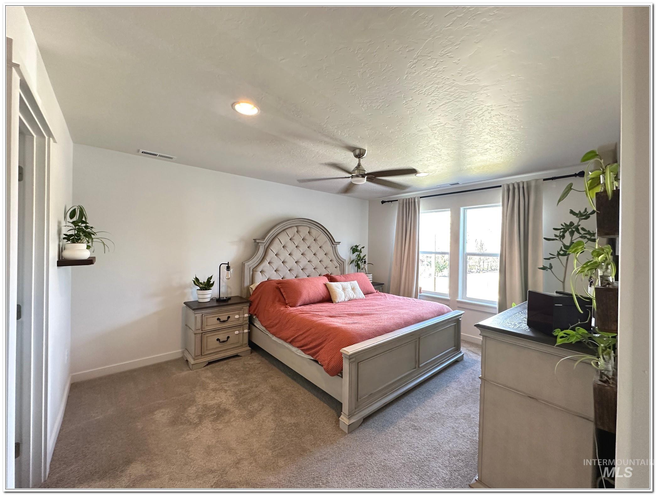 9687 West Arnold Road Boise, ID 83714 - Photo 18 of 49 Bedroom featuring light colored carpet, ceiling fan, and a textured ceiling