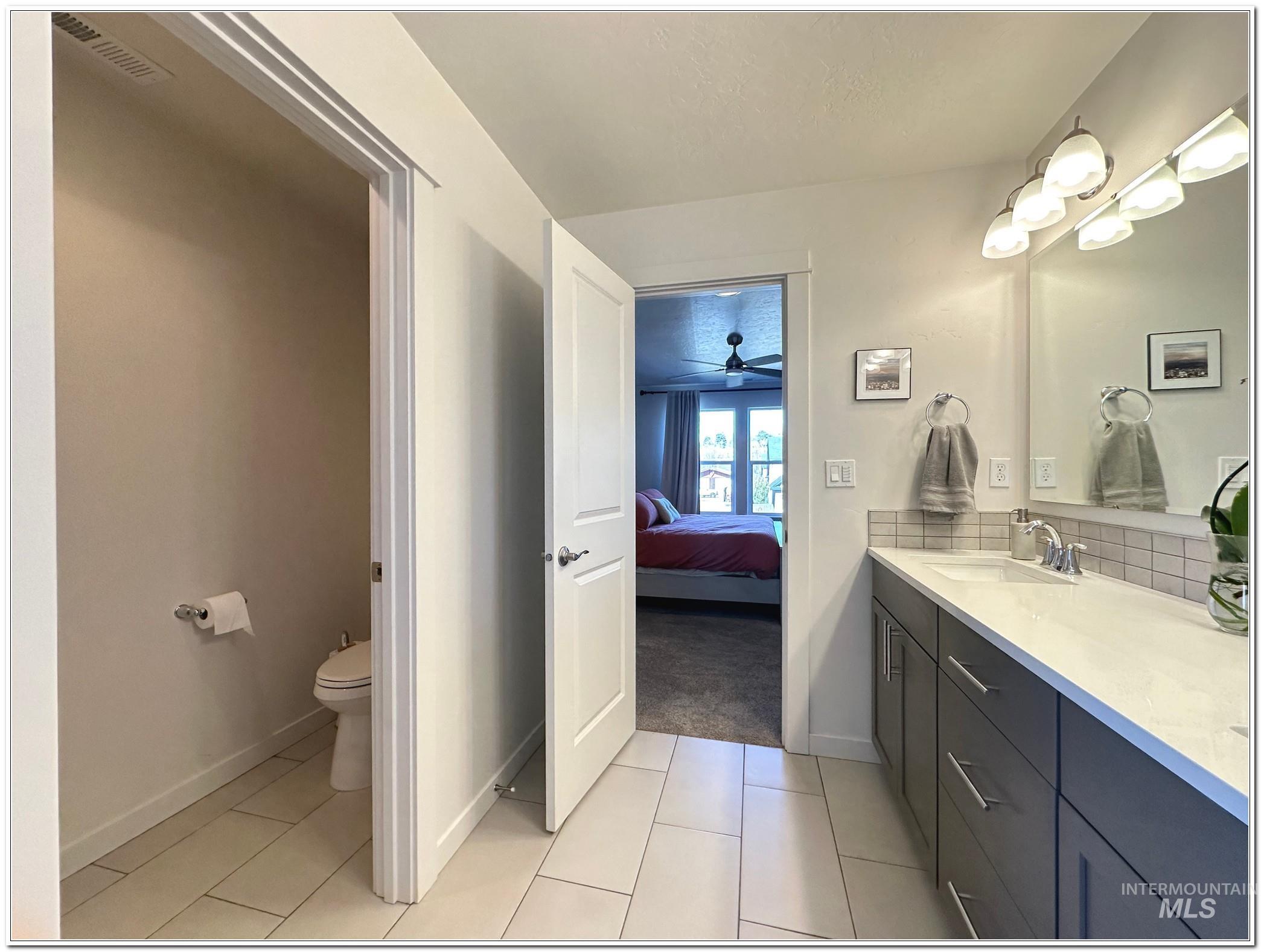 9687 West Arnold Road Boise, ID 83714 - Photo 24 of 49 Ensuite bathroom featuring vanity, light tile patterned floors, a ceiling fan, and backsplash