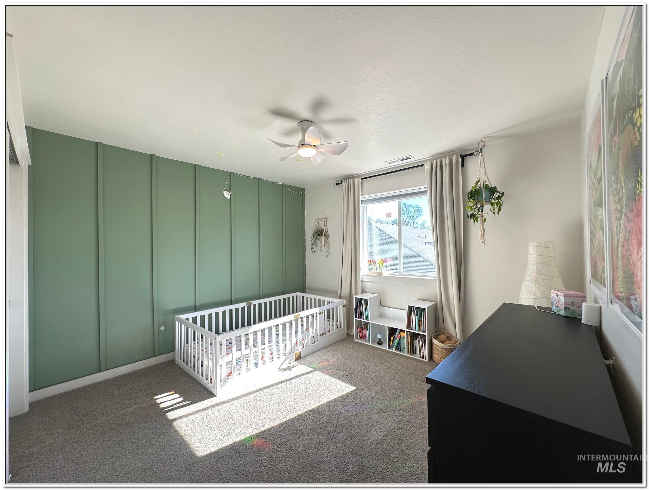 9687 West Arnold Road Boise, ID 83714 - Photo 28 of 49 Bedroom featuring a decorative wall, a nursery area, dark colored carpet, and ceiling fan