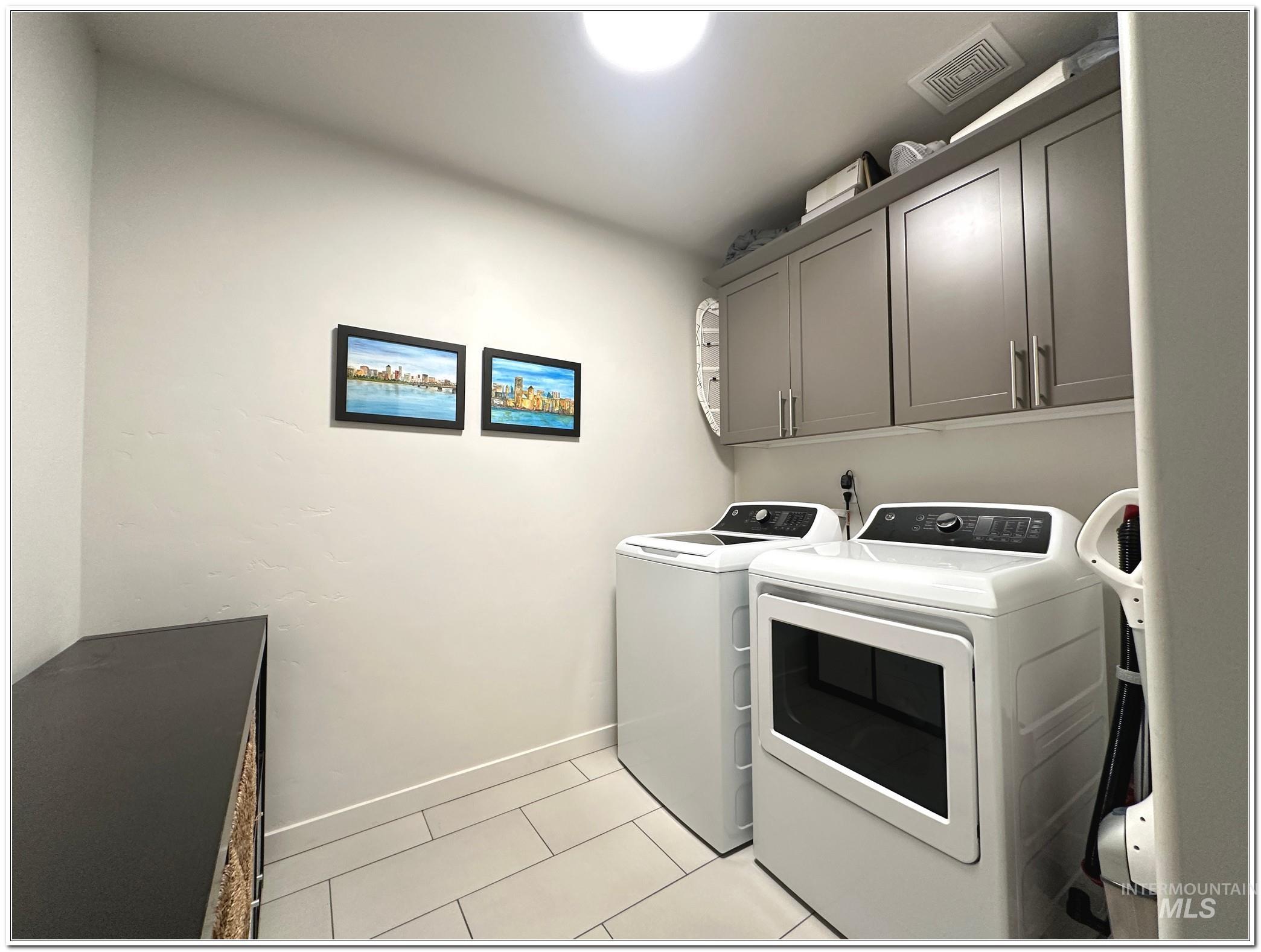 9687 West Arnold Road Boise, ID 83714 - Photo 33 of 49 Laundry area featuring separate washer and dryer, cabinet space, and light tile patterned floors
