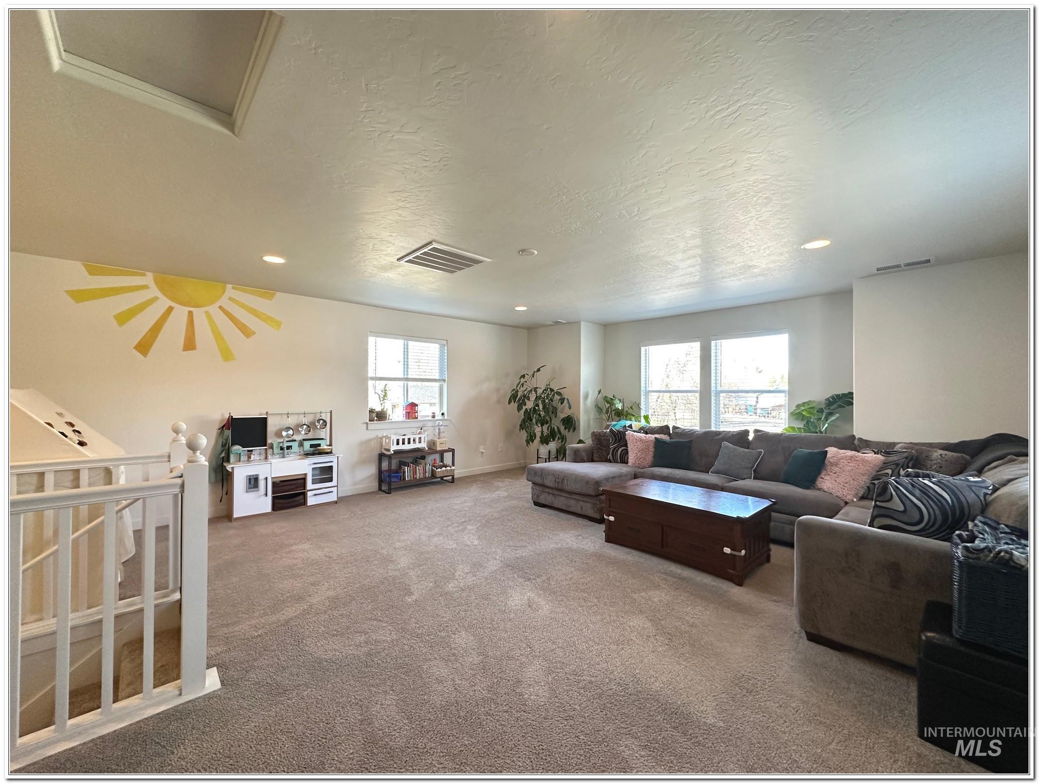 9687 West Arnold Road Boise, ID 83714 - Photo 36 of 49 Carpeted living room featuring a textured ceiling and recessed lighting