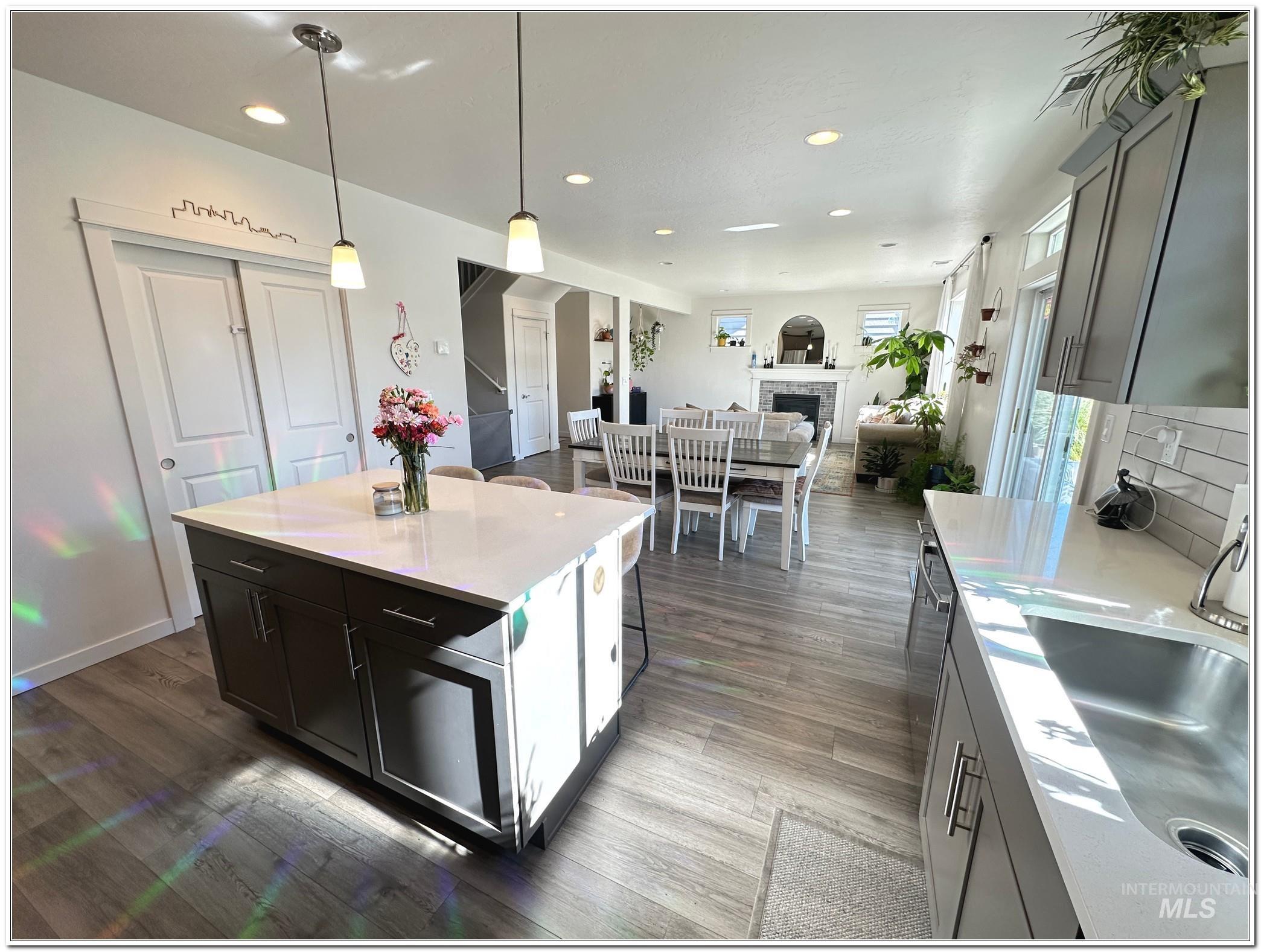 9687 West Arnold Road Boise, ID 83714 - Photo 48 of 49 Kitchen featuring hanging light fixtures, open floor plan, a center island, a kitchen bar, and a fireplace