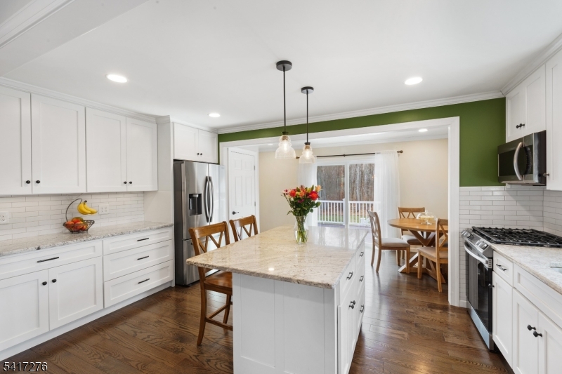 255 Dover Chester Road Randolph, NJ 07869 - Photo 7 of 37 a kitchen with stainless steel appliances kitchen island granite countertop a stove a sink a refrigerator and white cabinets with wooden floor