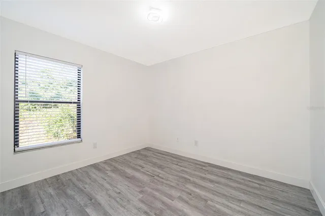 an empty room with wooden floor and a window