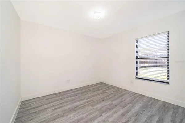 a view of a room that has wooden floor and a window