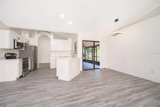 a view of kitchen with wooden floor and electronic appliances