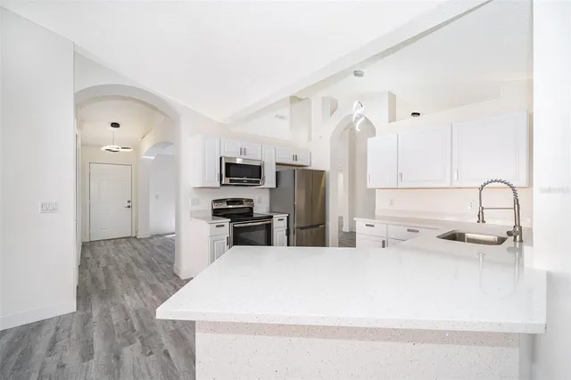 a kitchen with stainless steel appliances a refrigerator sink and microwave