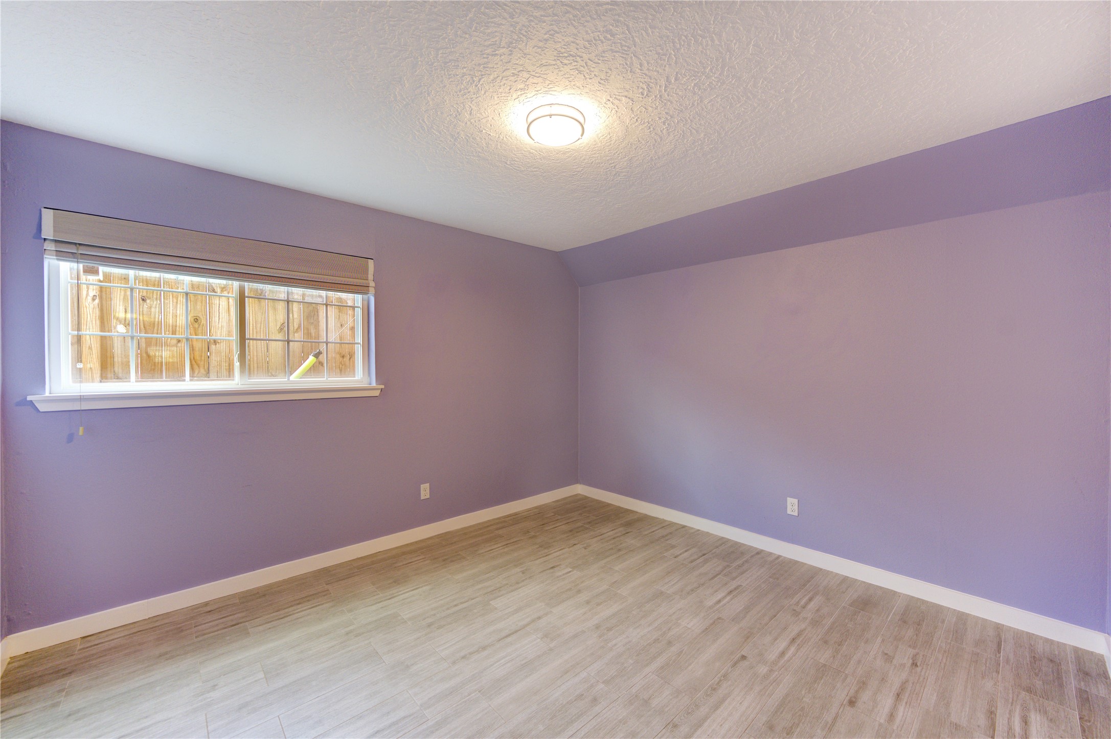 3224 Timmons Lane, Unit 155 Houston, TX 77027 - Photo 21 of 50 a view of an empty room with wooden floor and a window