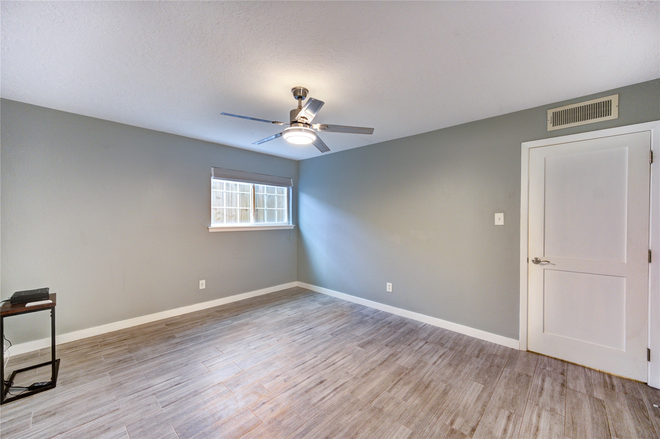 3224 Timmons Lane, Unit 155 Houston, TX 77027 - Photo 29 of 50 a view of an empty room with a window and wooden floor