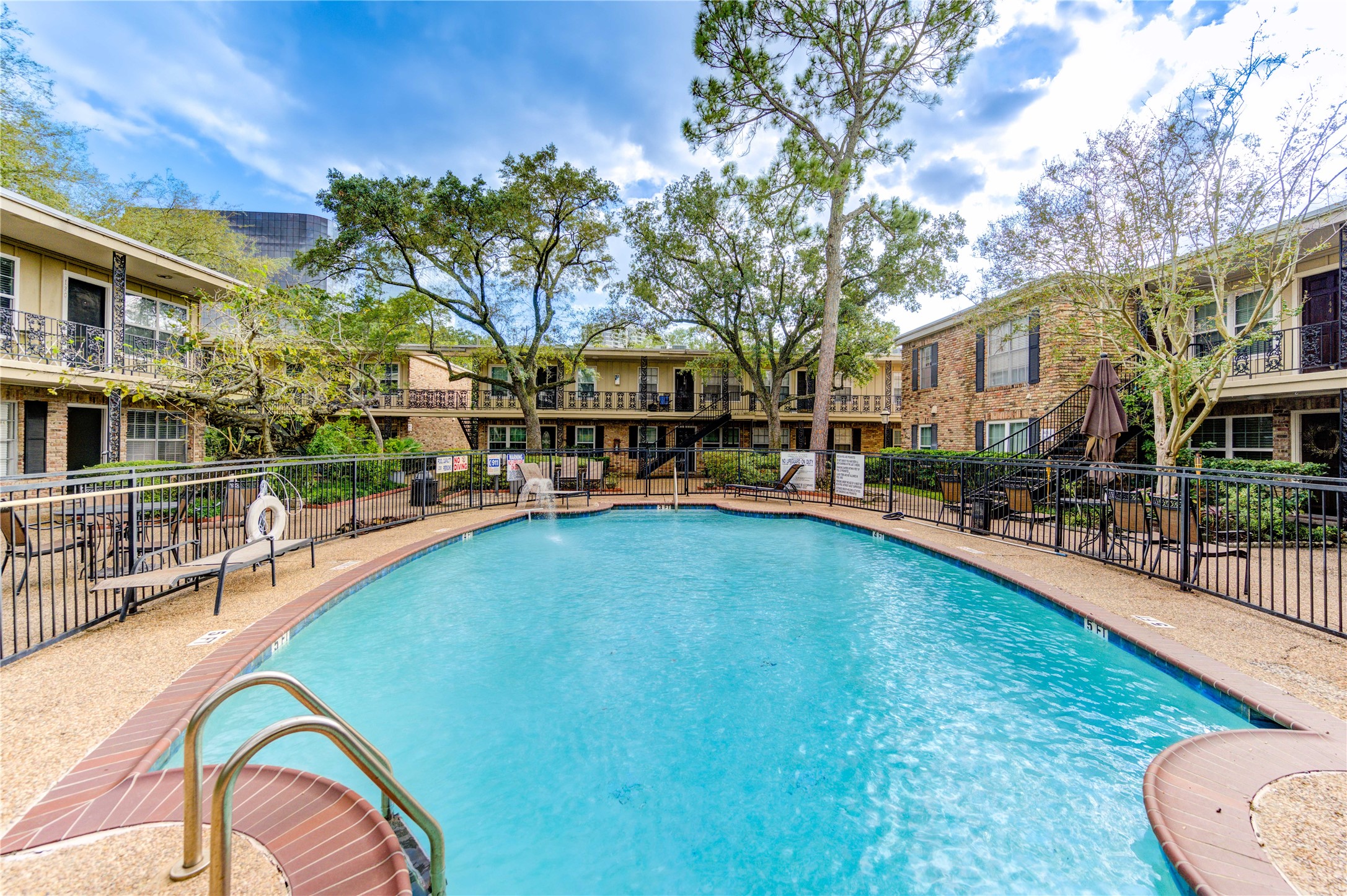 3224 Timmons Lane, Unit 155 Houston, TX 77027 - Photo 43 of 50 a view of a swimming pool with a bench and trees around