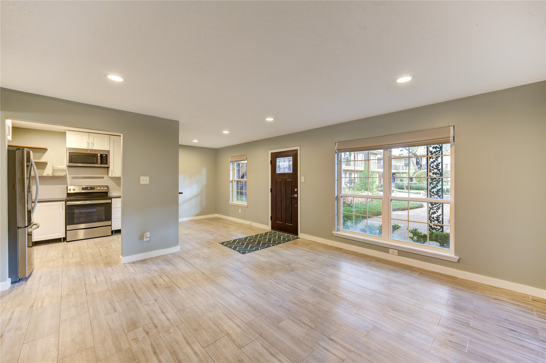 3224 Timmons Lane, Unit 155 Houston, TX 77027 - Photo 7 of 50 a view of an empty room with a window and wooden floor