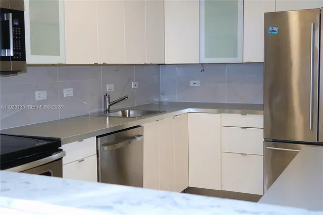 a view of a refrigerator in kitchen and white cabinets