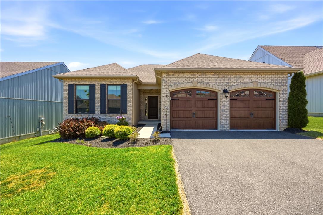 4120 Eveningstar Road Emmaus, PA 18049 - Photo 6 of 62 A welcoming brick facade with arched garage doors frames a meticulously landscaped front yard.