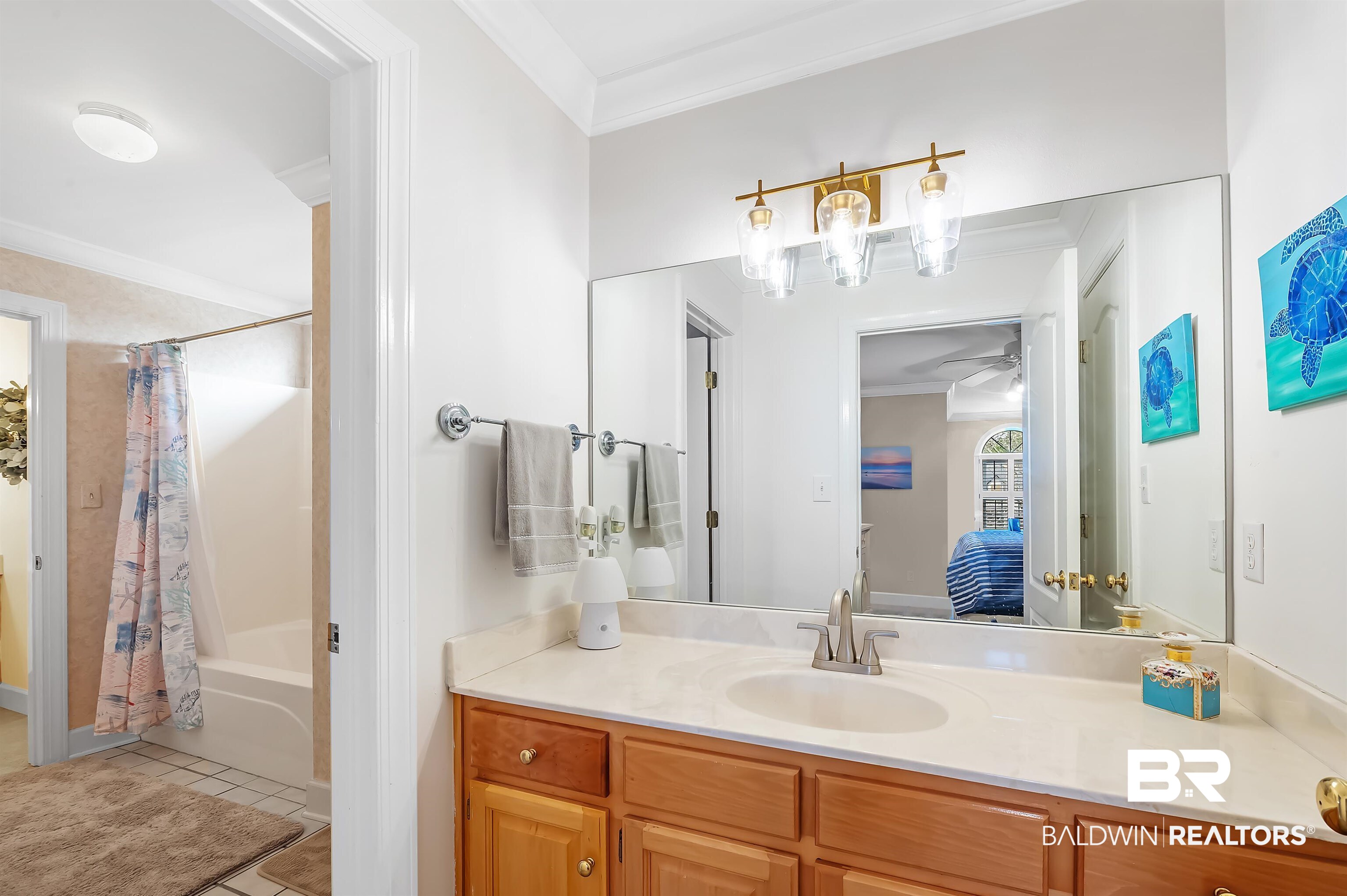8915 Bay Point Drive Elberta, AL 36530 - Photo 69 of 74 Ensuite bathroom with crown molding, shower / tub combo, vanity, ensuite bath, and tile patterned floors