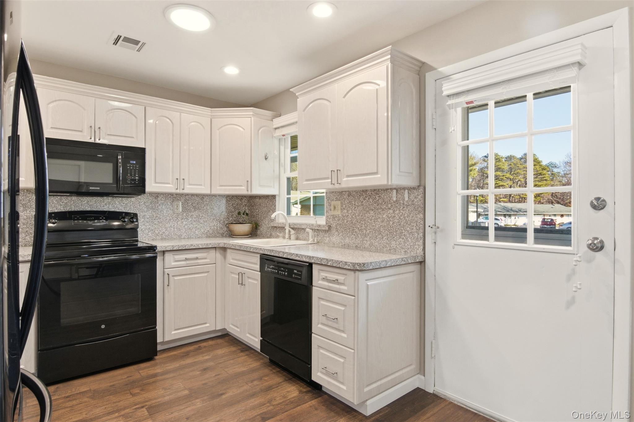 360 Woodbridge Drive, Unit A Ridge, NY 11961 - Photo 11 of 34 a kitchen with stainless steel appliances granite countertop a stove a sink and a microwave