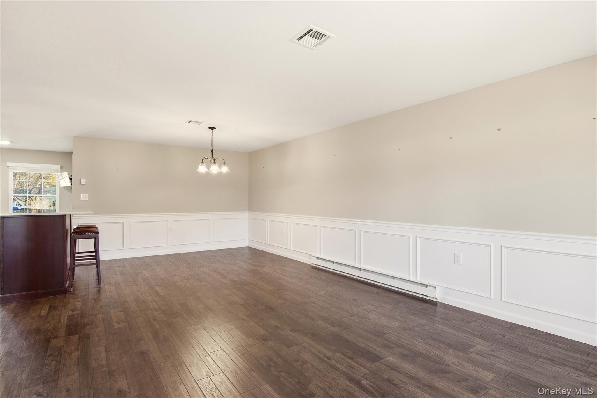360 Woodbridge Drive, Unit A Ridge, NY 11961 - Photo 6 of 34 an empty room with wooden floor and windows