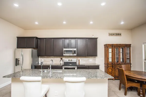 a kitchen with stainless steel appliances granite countertop a sink refrigerator and cabinets