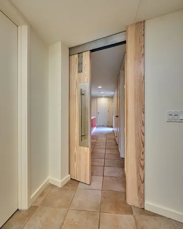 a view of a hallway with a livingroom and a bathroom