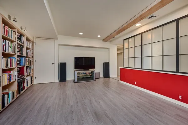a living room with furniture flat screen tv and a book shelf