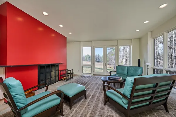 a living room with furniture a flat screen tv and a large window