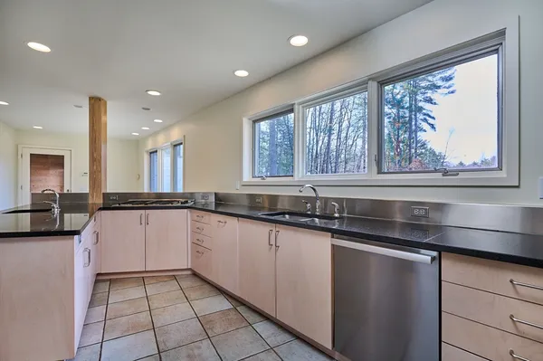 a kitchen with granite countertop a sink and a stove top oven