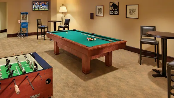 a room with furniture pool table and a flat screen tv