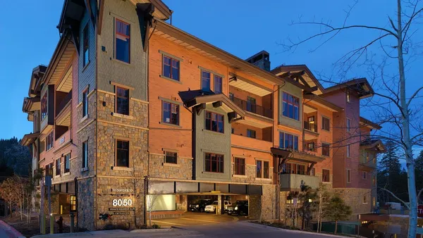 a front view of a building with lot of cars