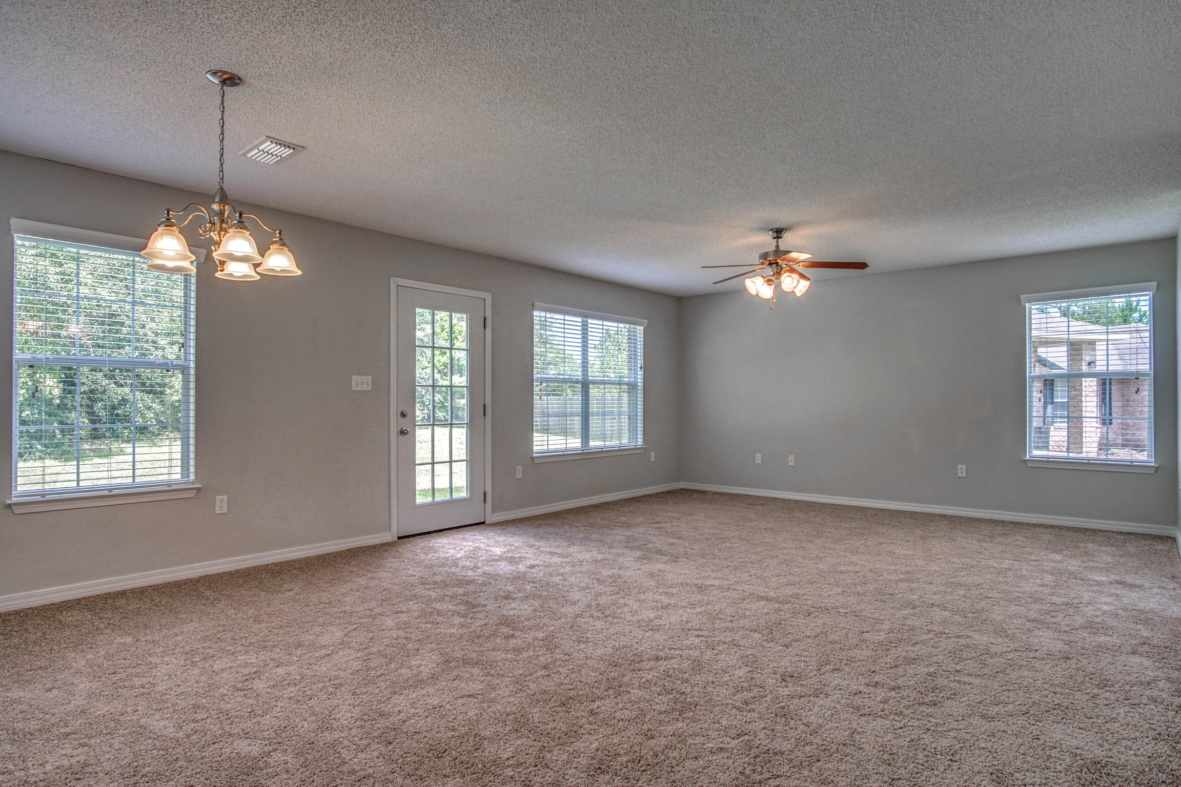 412 Plate Drive Crestview, FL 32539 - Photo 5 of 25 an empty room with chandelier fan and windows