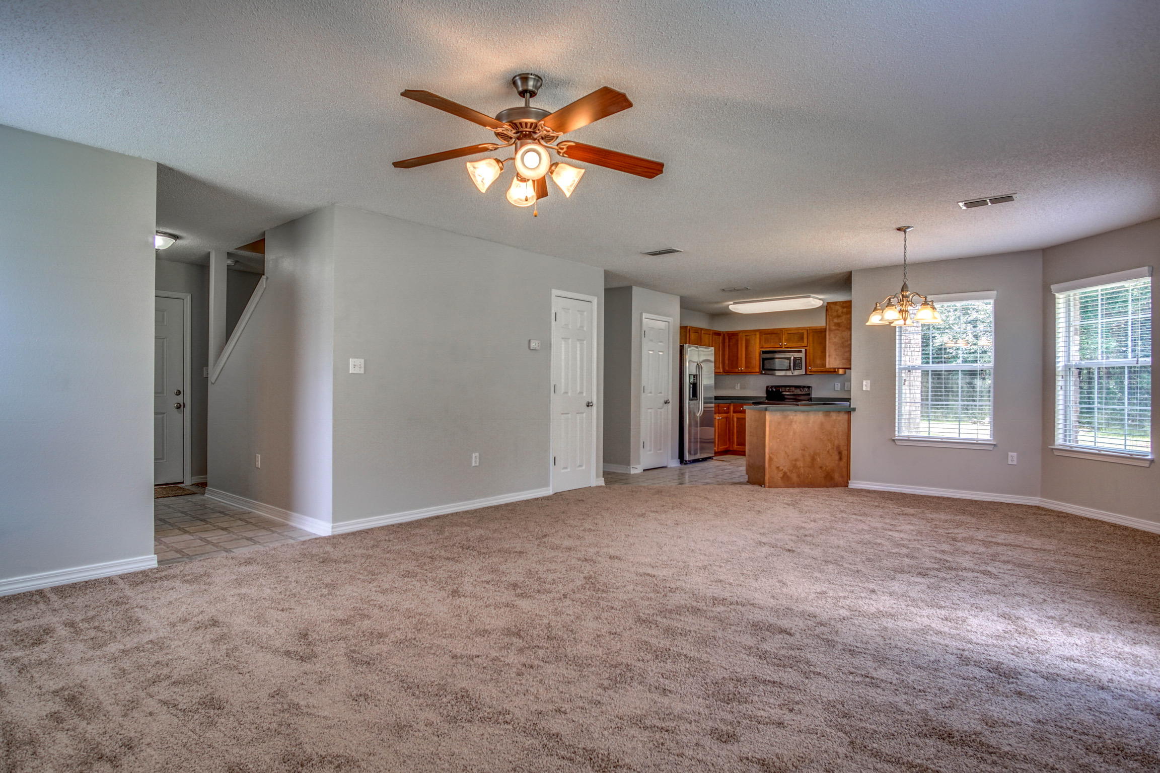412 Plate Drive Crestview, FL 32539 - Photo 9 of 25 an empty room with chandelier fan and windows