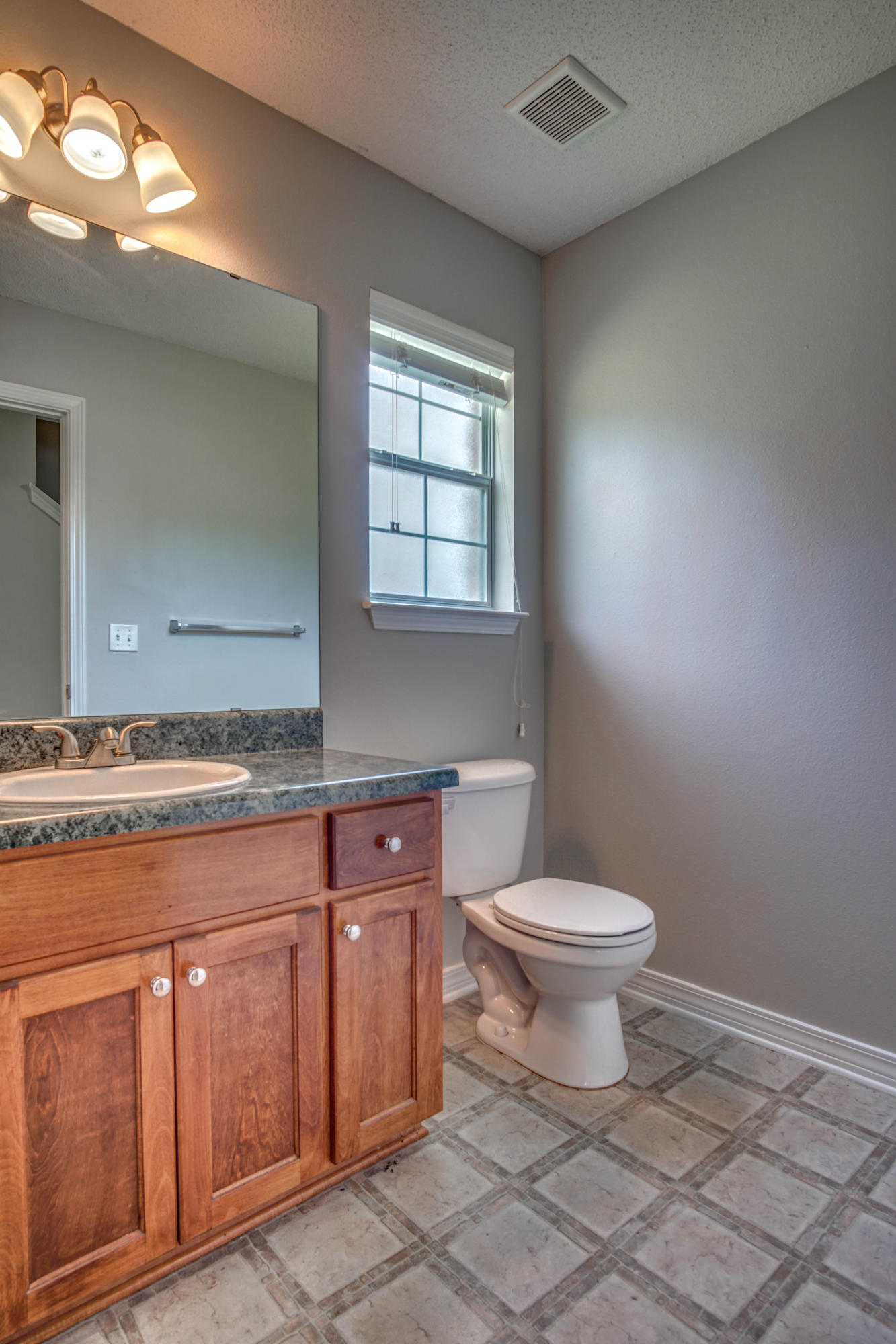 412 Plate Drive Crestview, FL 32539 - Photo 10 of 25 a bathroom with a granite countertop toilet a sink and a window