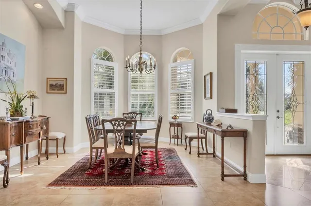 a dining room with wooden floor a chandelier a wooden table and chairs