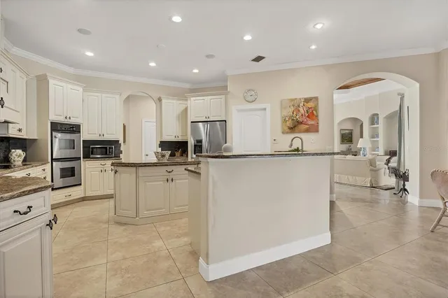 a large white kitchen with cabinets