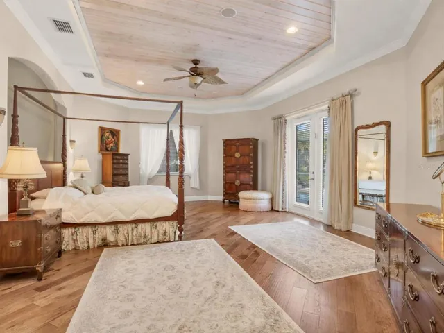 a spacious bedroom with a large bed a chandelier and closet