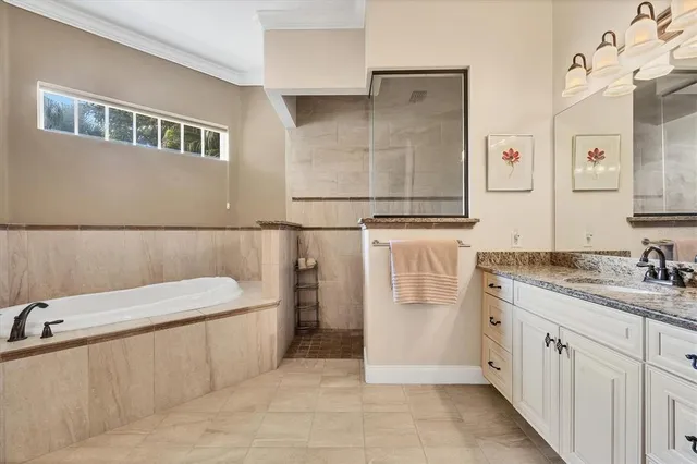 a bathroom with a granite countertop sink a mirror and a bathtub