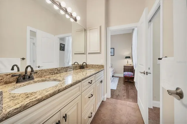 a spacious bathroom with a granite countertop sink and a mirror