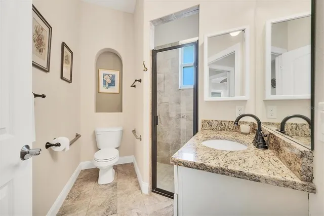 a bathroom with a granite countertop sink toilet and shower