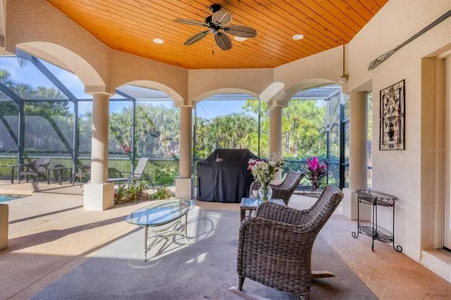 a living room with patio furniture and a floor to ceiling window