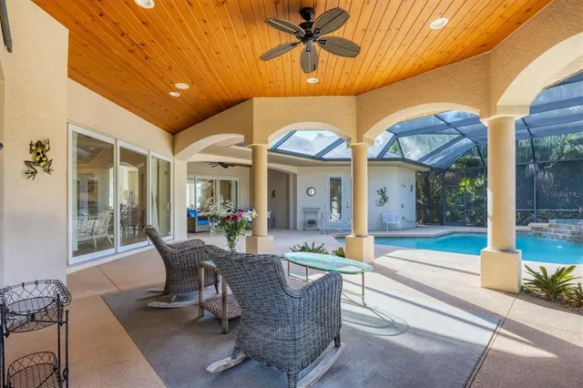 a view of a patio with table and chairs and floor to ceiling window