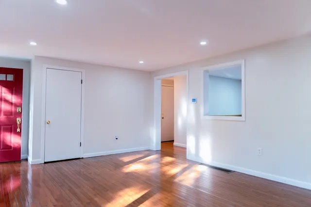 a view of an empty room with wooden floor