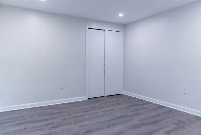 a view of an empty room with wooden floor